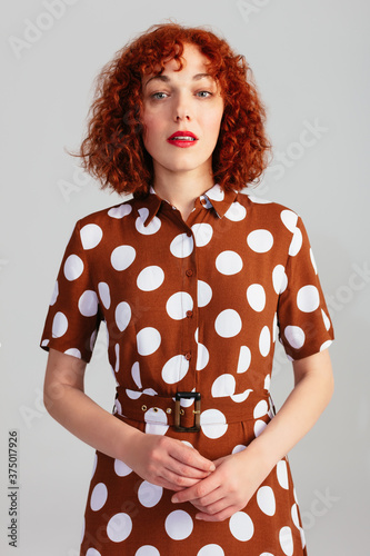Stylish Red Haired Woman In Studio photo