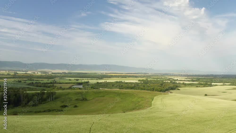 Scenic aerial panoramic view of idyllic rolling hills spring landscape in with lush green mountain pastures in evening light at sunset Scenic aerial panoramic view of idyllic rolling hills spring landscape in with lush green mountain pastures in evening light at sunset