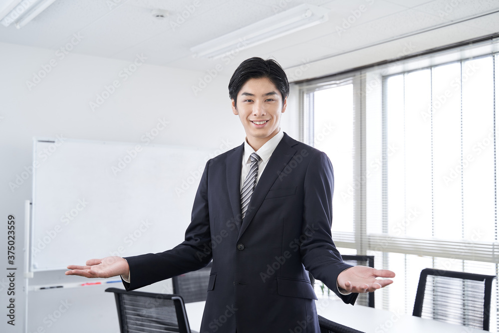 Fototapeta premium 会議室で笑顔で両手を広げる日本人男性ビジネスマン
