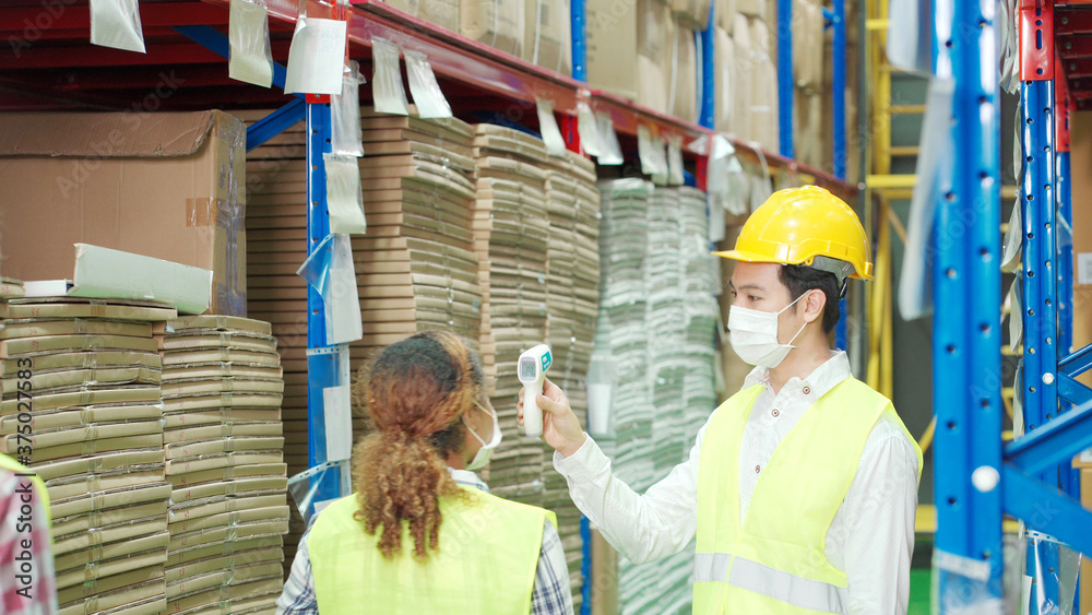 Multi ethnic workers check temperature as new normal in warehouse Multi ethnic workers check temperature as new normal in warehouse
