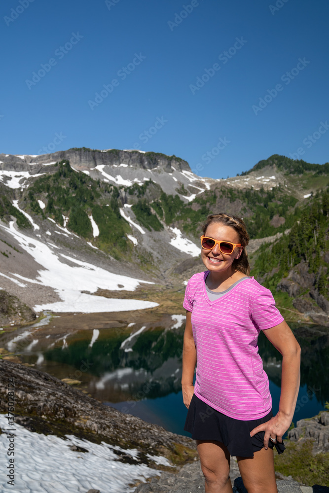 Woman wearing sunglasses and smiling poses at Heather Meadows in Mt Baker, Washington State