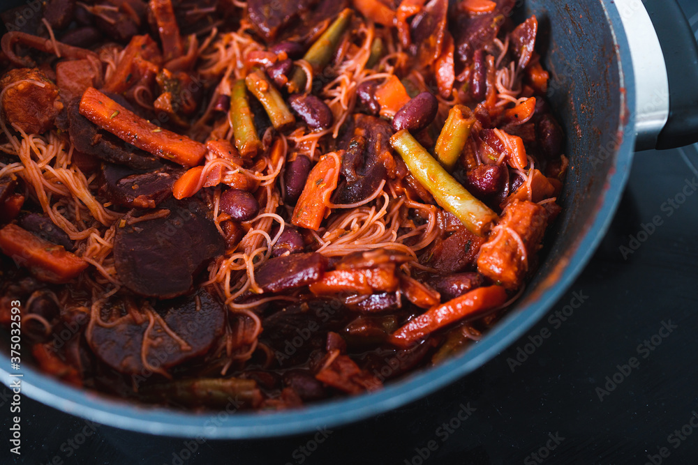 plant-based food, vegan beetroot and vegetables stir fry with vermicelli noodles in pot getting cooked plant-based food, vegan beetroot and vegetables stir fry with vermicelli noodles in pot getting cooked