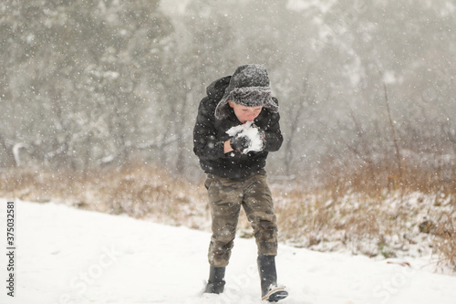 Boy carrying snow balls while snowing in New South Wales  Australia. Winter 2020
