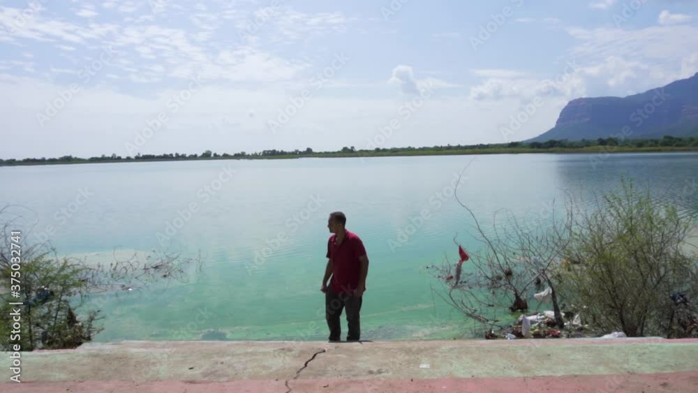 man at Vadatalav lake. man enjoying nature and pavagadh mountain man at Vadatalav lake. man enjoying nature and pavagadh mountain