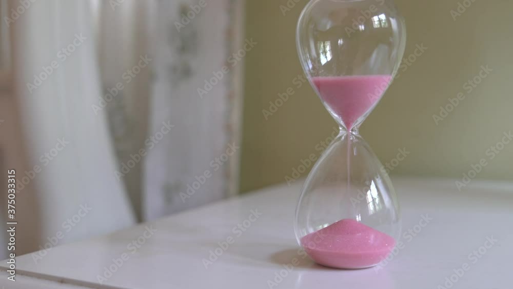 Close up shot of sand clock measuring time while the sand is falling