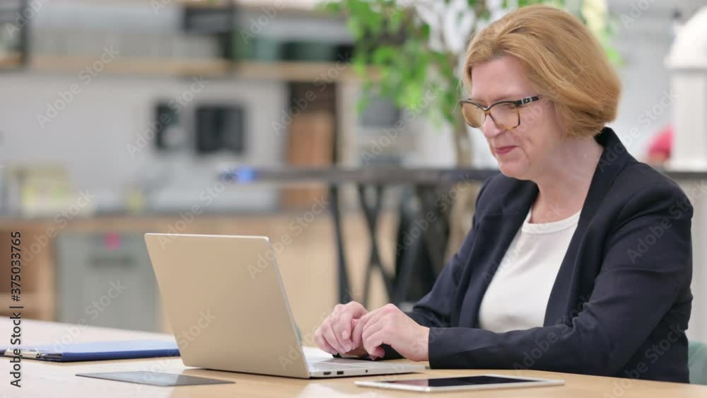 Old Businesswoman doing Video Call on Laptop in Office 