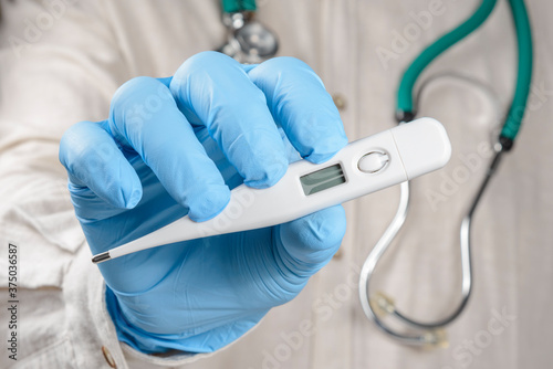 hand holding digital thermometer.
