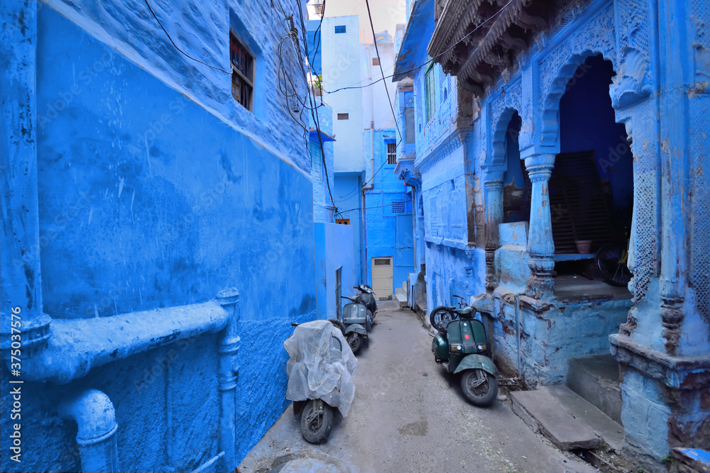 Scooters parked in a narrow blue coloured street in Jodhpur.