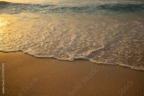 Scenic seascape. Milky foam waves at the beach. Sunset time. Waterscape for background. Selected soft art focus. Sunlight reflection on the water and sand. Copy space. Balangan beach  Bali  Indonesia