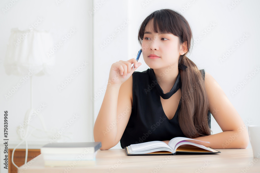 Asian woman writer smiling thinking idea and writing on notebook or diary with happy on desk office, lifestyle of asia girl is success, female planning working, education and business concept. Asian woman writer smiling thinking idea and writing on notebook or diary with happy on desk office, lifestyle of asia girl is success, female planning working, education and business concept.