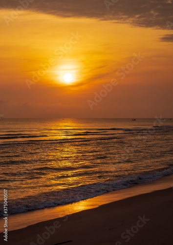 Ocean at dawn with the sun's golden orb against the background glow of sunrise. © wrightouthere