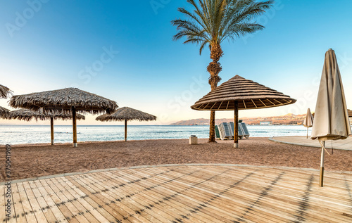 Fototapeta Naklejka Na Ścianę i Meble -  Morning at a public beach of Eilat - famous tourist resort and suitable for perfect vacations and holidays, entertainments and shopping, relaxing at beaches, swimming and diving among coral reefs  