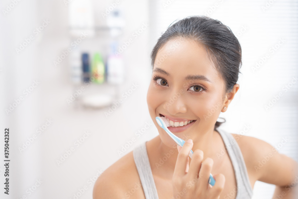Beautiful female brushing teeth in the bathroom Beautiful female brushing teeth in the bathroom