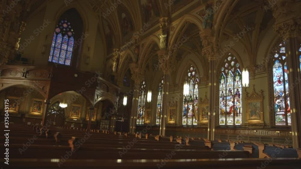 shot over a churches pews viewing stained glass and murals shot over a churches pews viewing stained glass and murals