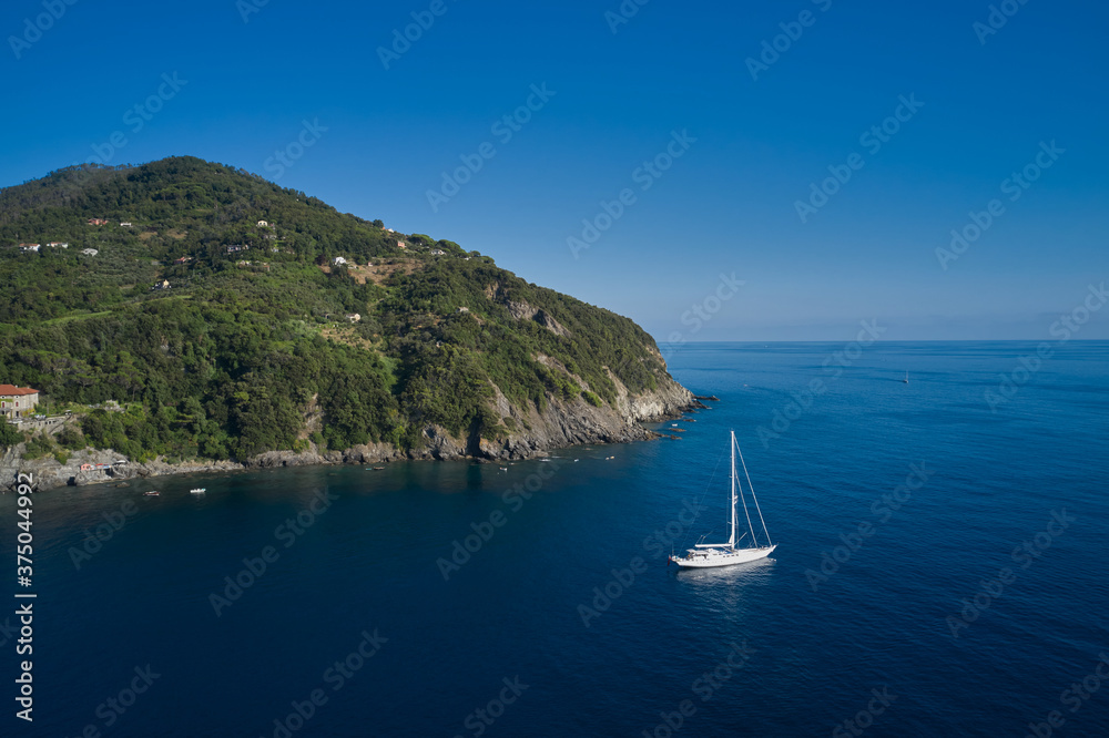 Large white sailboat on the sea near the rocks. The coastline of the seaside resort. Italian resorts.