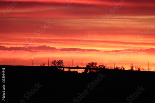vibrant sunset silhouette on a shadowy prarie © Aiden
