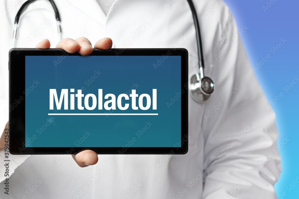 Mitolactol. Doctor holds a tablet computer in his hand. Close up. Text is on the display. Blue Background Mitolactol. Doctor holds a tablet computer in his hand. Close up. Text is on the display. Blue Background