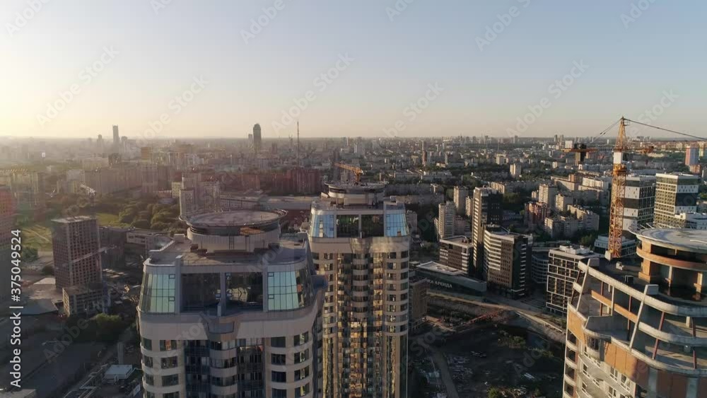 Aerial view of Multi-storey buildings in the city. People on the roof and party. Some houses have been built, one house is still under construction. There are helipads on the rooftops. Aerial view of Multi-storey buildings in the city. People on the roof and party. Some houses have been built, one house is still under construction. There are helipads on the rooftops.