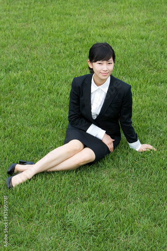 young businesswoman sitting on grass