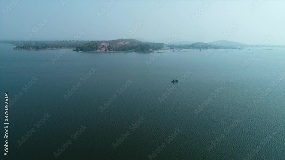 Aerial Shot of Rowing Single Rowboat in River With Mountains in background. Aerial Shot of Rowing Single Rowboat in River With Mountains in background.