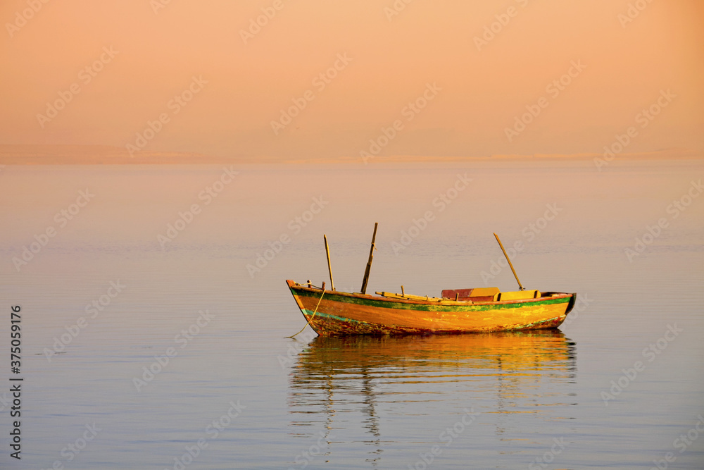 Fototapeta premium empty orange boat used by local fishermen living near lake Qaroun in El Fayoum south of Cairo. 