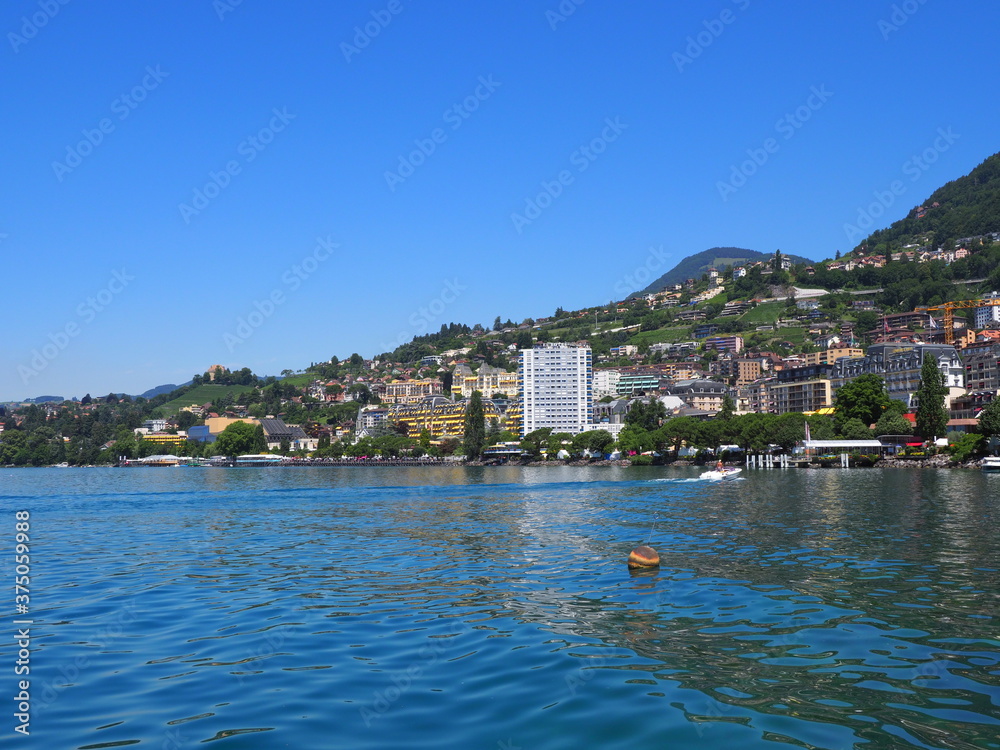 MONTREUX, SWITZERLAND on JULY 2017: Scenic townscape of Lake Geneva and european city in canton Vaud, clear blue sky in warm sunny summer day.