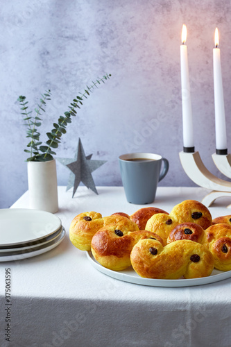 Plate of Swedish Saffron Bun w/ Coffee and Candles, Plates on the side photo