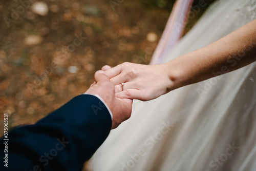 The lovely couple in love hold of hands. Stylish wedding ring. Proposal. Engagement. Bride and groom in marriage.
