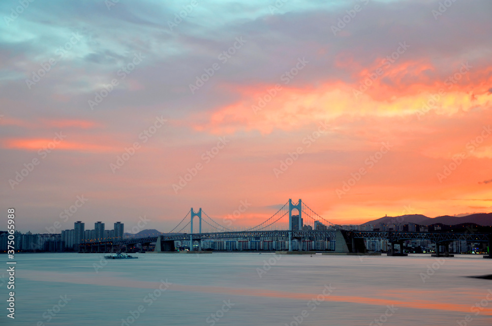 Fototapeta premium Dongbaek island and Gwangandaegyo bridge during colorful sunset in Busan city, South Korea