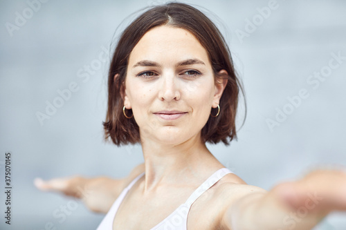 Frau/Mädchen in Pastell gekleidet macht Outdoor Yoga Übungen/Sonnegruß in moderner Beton Architektur. Urbanes Leben. 
 photo