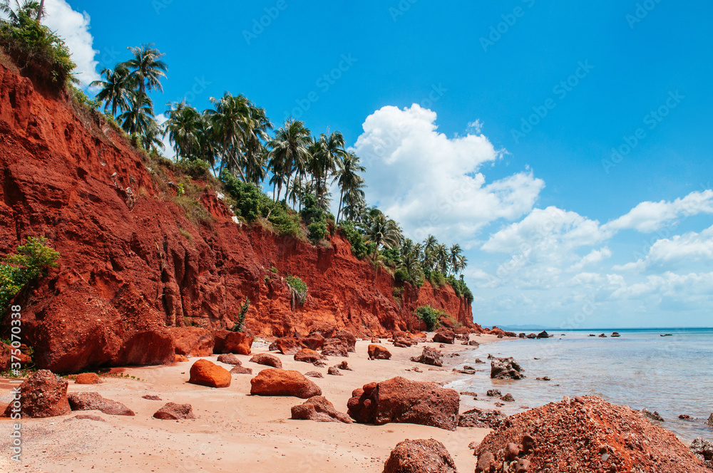 Tropical island red cliff  rock beach with blue sky and clouds in summer, tranquil serene ocean scenery. Fang Daeng in Prachuap Khiri Khan. Thailand