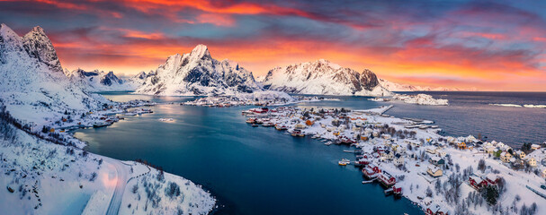 Panoramic evening view from flying drone of popular tourist destination - Reine town. Amazing sunset on Lofoten Islands, Norway,. Colorful winter seascape of Norwegian sea. Life over polar circle..