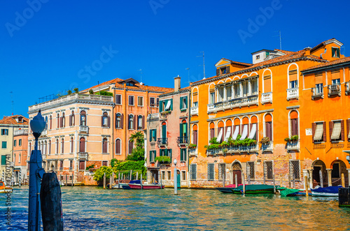 Grand Canal waterway with colorful multicolored palace buildings and moored boats in Cannaregio sestiere Venice historical city centre, blue clear sky background in summer day, Veneto Region, Italy photo
