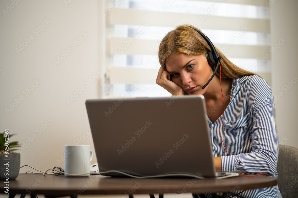 Young modern woman is working from home. She is tired of using computer all day. Young modern woman is working from home. She is tired of using computer all day.