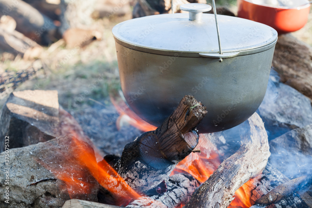 Bonfire and metal cauldron. Cooking on open fire Bonfire and metal cauldron. Cooking on open fire