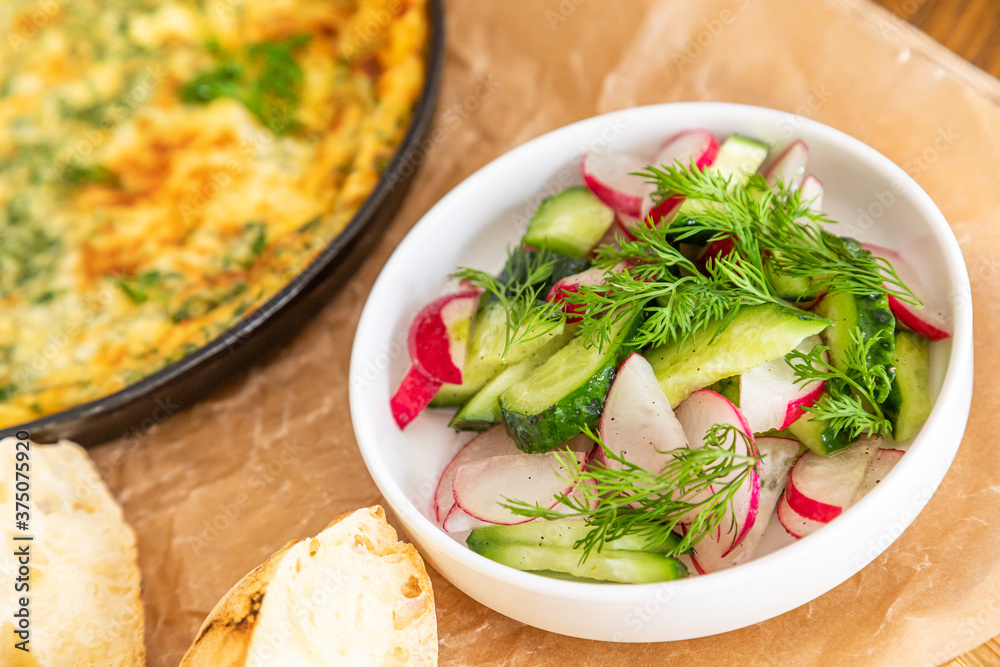 Omelet in a frying pan with parsley and dill. Serve with fresh bread and fresh vegetables. Omelet in a frying pan with parsley and dill. Serve with fresh bread and fresh vegetables.