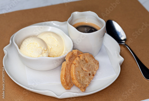 View of Affogato dessert included almond cookies, vanilla ice cream and cup of espresso, served at Italian restaurant photo