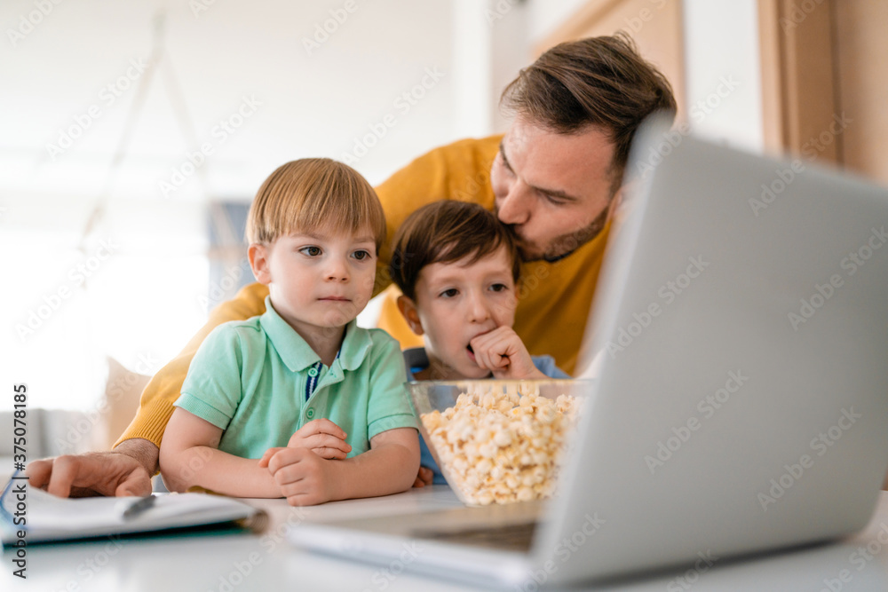 Beautiful happy family with child looking at laptop with cheerful smile Beautiful happy family with child looking at laptop with cheerful smile