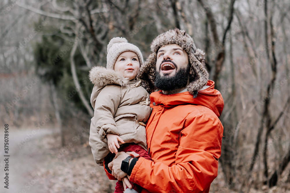 happy family concept. Father and baby daughter playing and laughing on cold winter walk in park.