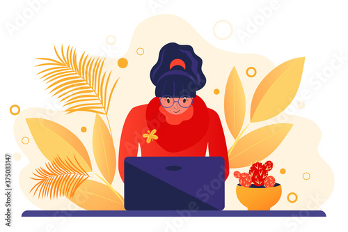 A young woman working at a computer. Online education. Freelance worker, self-employed, student. Autumn workplace interior design.