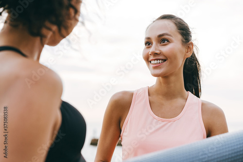 Image of joyful multinational sportswomen talking after workout © Drobot Dean