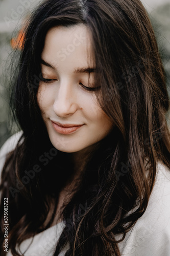 portrait of a pretty young girl dressed in a long linen dress posing for a photo among flowers at a home mini flower farm