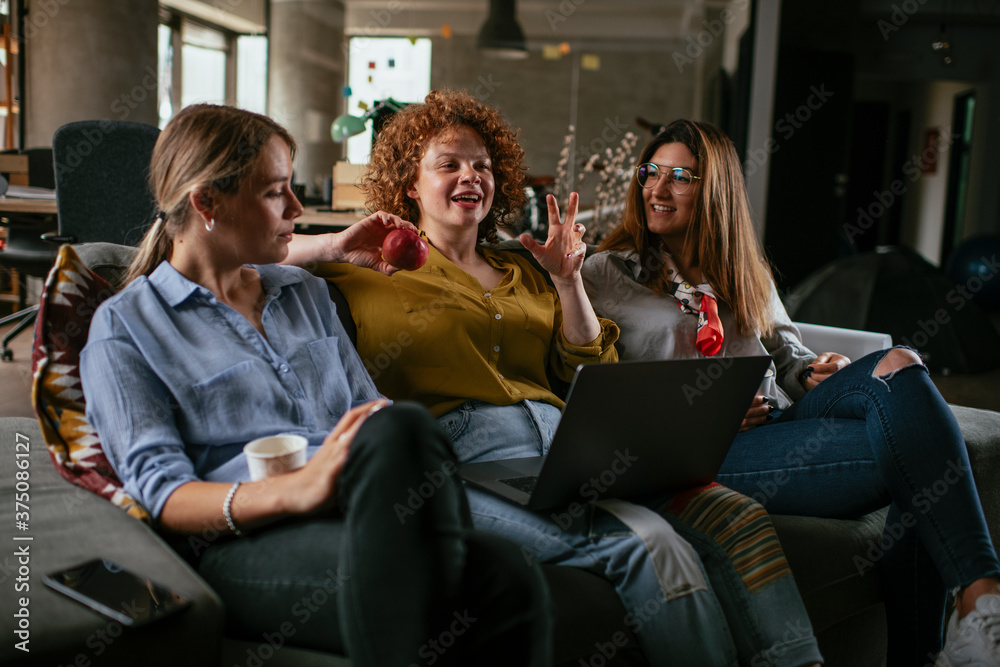 Girlfriends talking and laughing in office. Beautiful women drinking coffee in the office. Girlfriends talking and laughing in office. Beautiful women drinking coffee in the office.