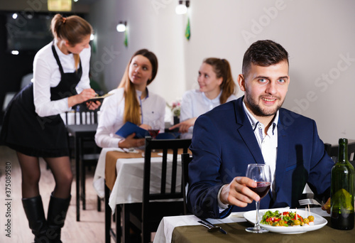 Gentleman is having dinner in luxury restaurante indoor.