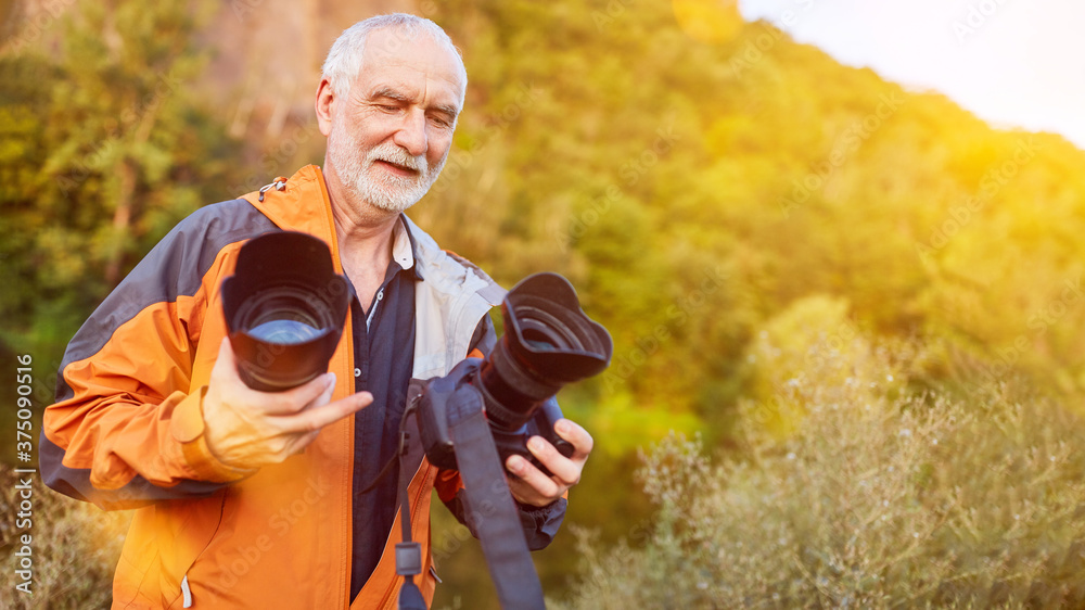 Fototapeta premium Fotograf beim Objektiv wechseln in der Natur