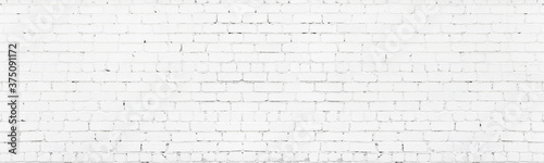 White painted wide brickwork. Whitewashed old shabby exterior brick wall texture. Large long light background