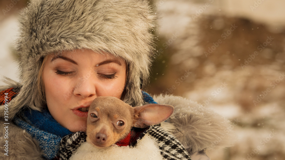 Woman hug warming her little dog in winter Woman hug warming her little dog in winter