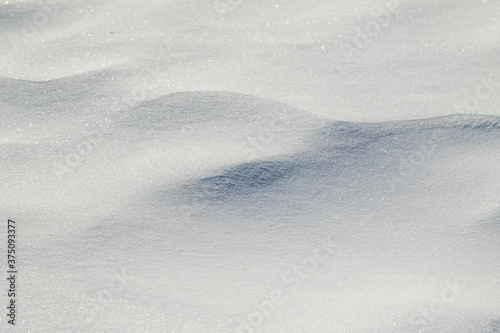 Snow background, light shadow, steppe snow cover. Large white snowy winter background.