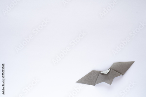 gray origami bat on white background