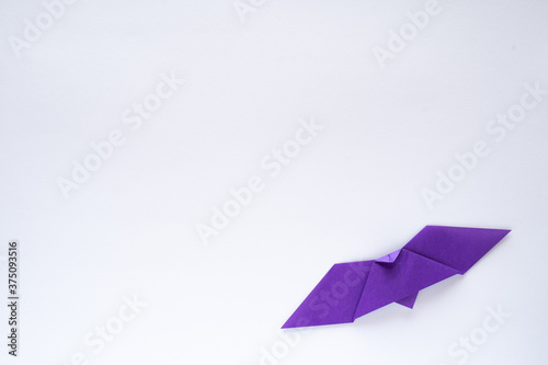 purple origami bat on white background